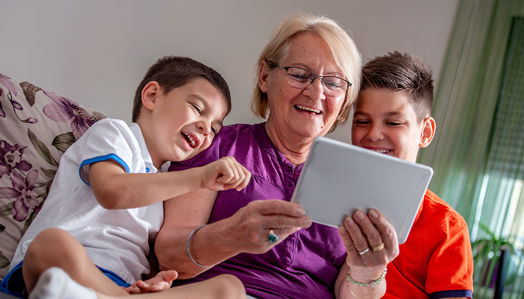 grandma on an iPad with two grand children